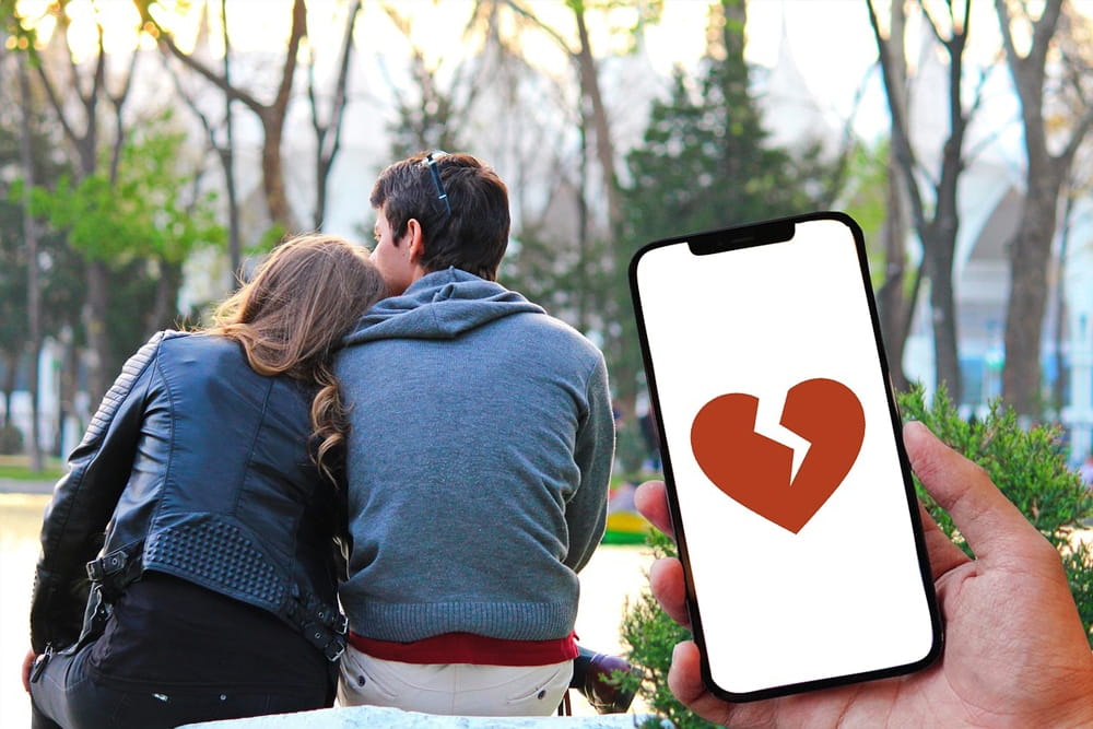 Paar im Park und Smartphone mit gebrochenem Herz als Symbol für Ehebruch, Fremdgehen und private Ermittlungen in Berlin