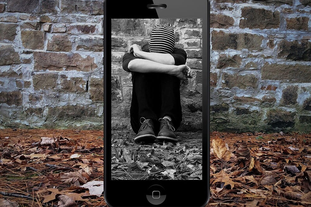 Person in einem Smartphone als Symbol für Online-Belästigung, Cybermobbing und digitale Dokumentation von Vorfällen durch die Detektei Fahtz
