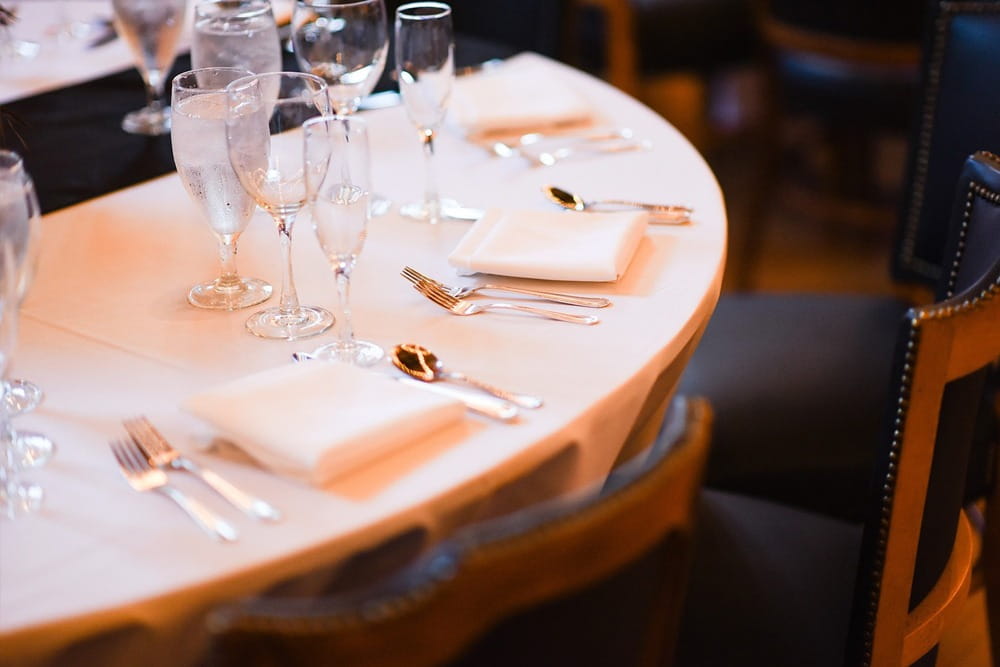 Gedeckter Restauranttisch als Symbol für Bewirtungskosten, Spesenbetrug und Abrechnungsbetrug in Unternehmen