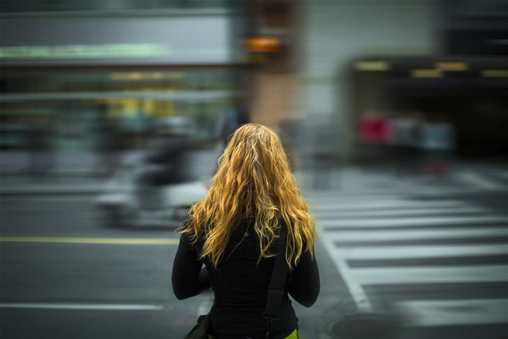 Frau an einer Straße mit unscharfem Hintergrund als Symbol für Stalking, Nachstellung und die Dokumentation wiederkehrender Vorfälle durch die Detektei Fahtz in Berlin