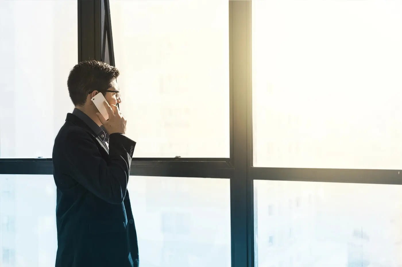 Mann beim Telefongespräch am Fenster als Symbol für vertrauliche Fallabstimmung, Ermittlungsplanung und persönliche Beratung der Detektei Fahtz Berlin